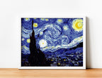 Cuadro de La Noche Estrellada de Van Gogh pintado en estilo por números con marco blanco sobre mesa de madera clara.
